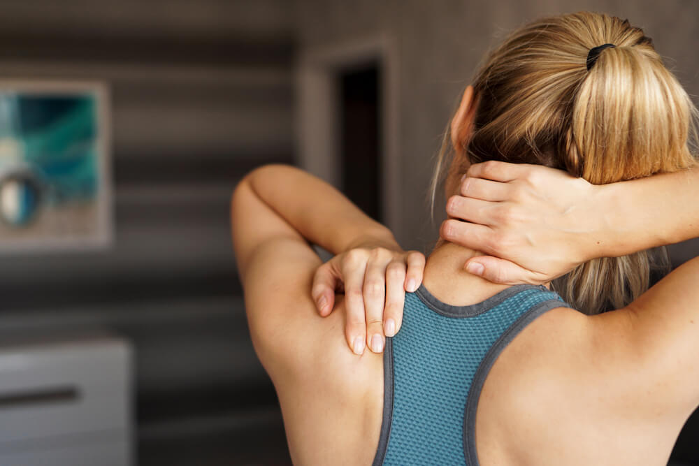 Athletic woman feeling pain in her neck