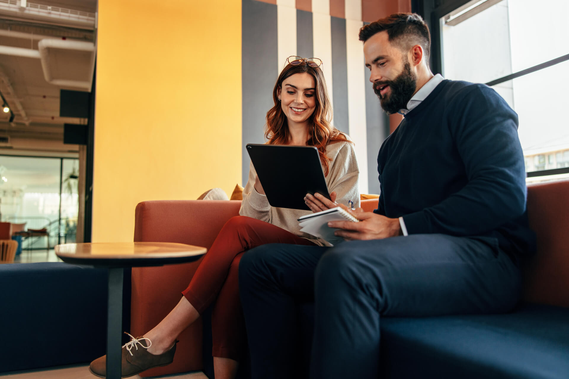 Happy businesspeople working together in an office lobby.