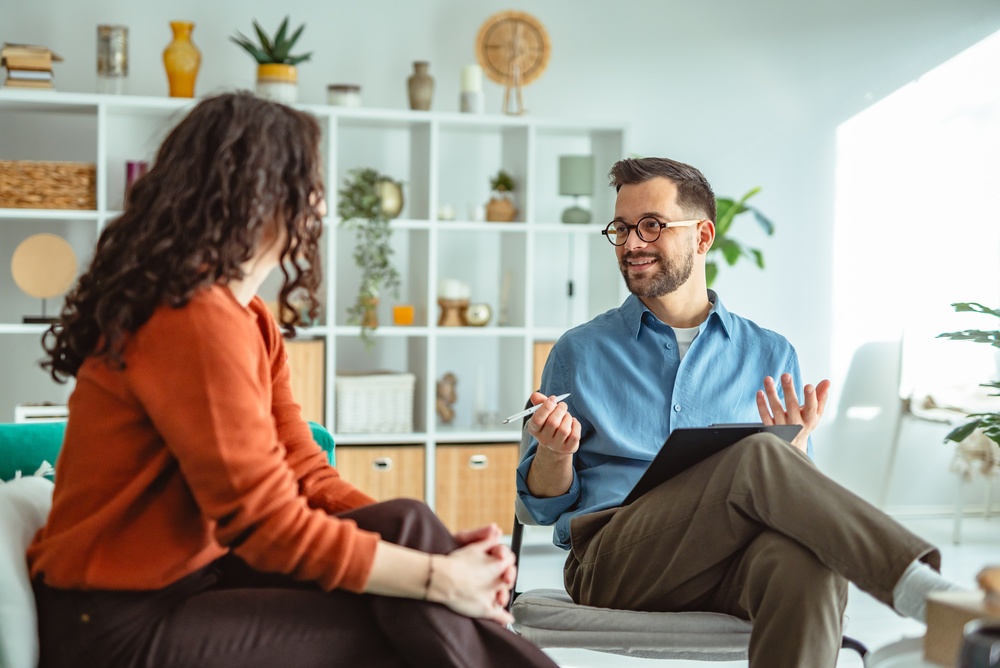 Young woman receiving support and advice from a male psychologist