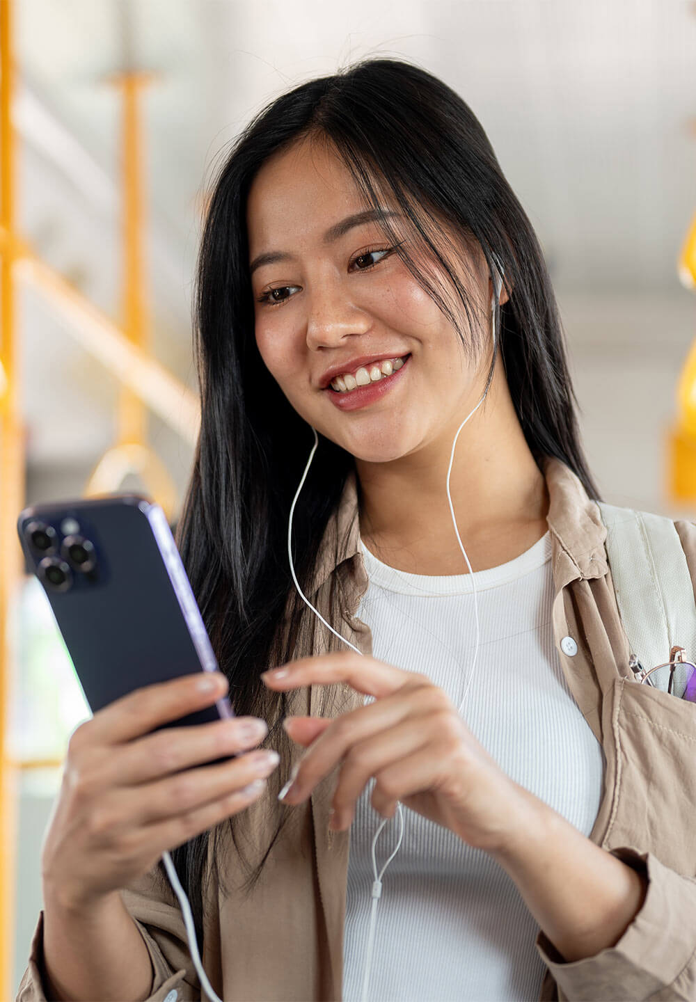 A beautiful woman in casual clothes listens to music and uses her smartphone