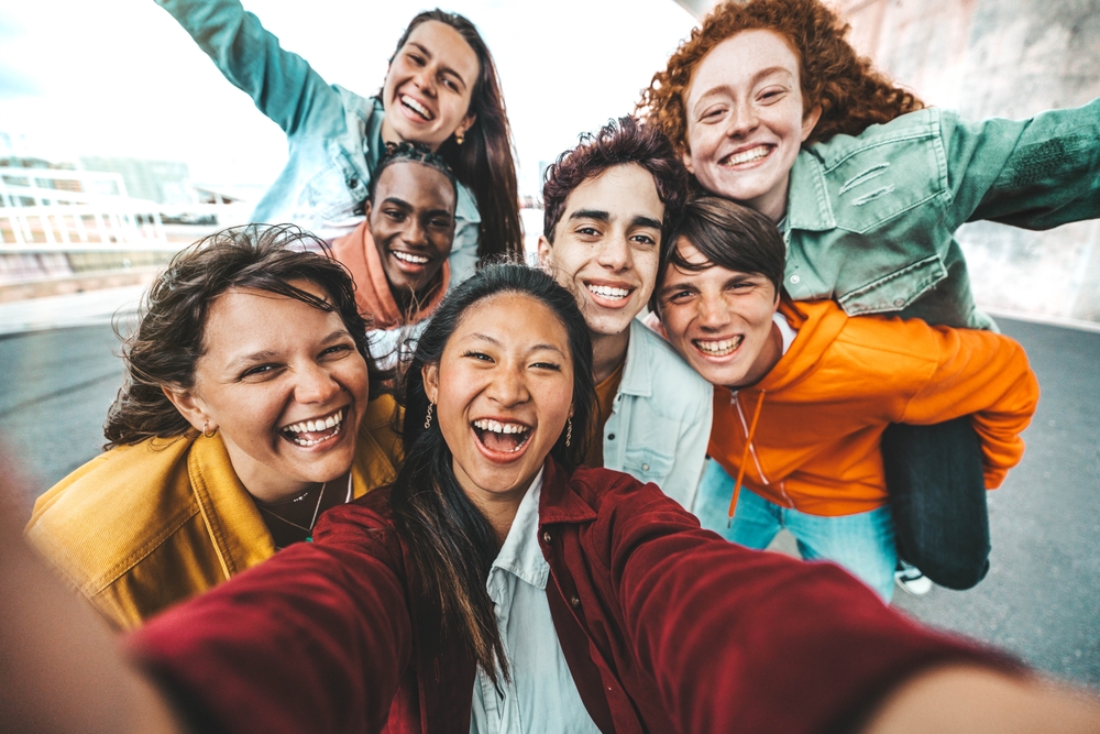 Happy friends taking selfie with smart mobile phone
