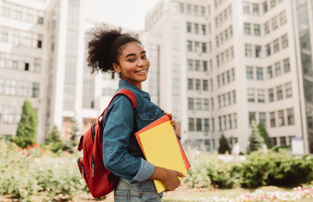 Happy college Girl Holding Books