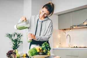 Young Woman Making Detox Smoothie At Home