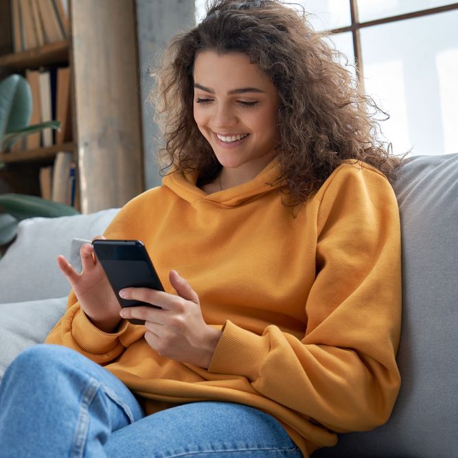 Smiling young woman using mobile phone