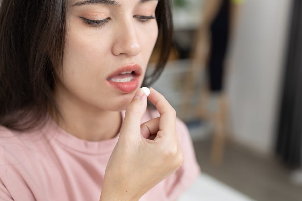 Close-up of women taking white pill, showing medication, treatment or health care concept