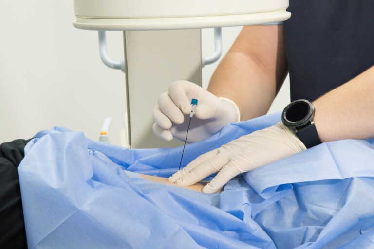 A medical professional gives an injection into the patient's arm