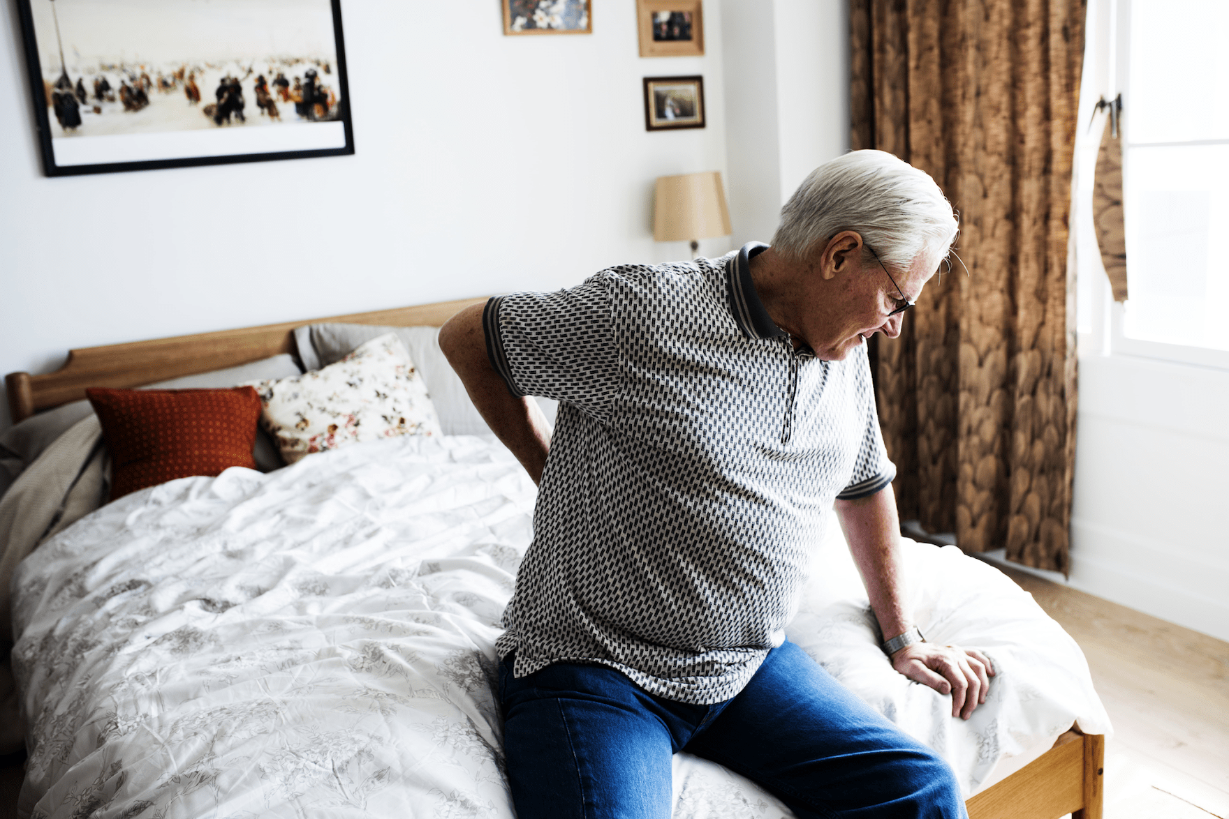 Aged man holding his back in pain
