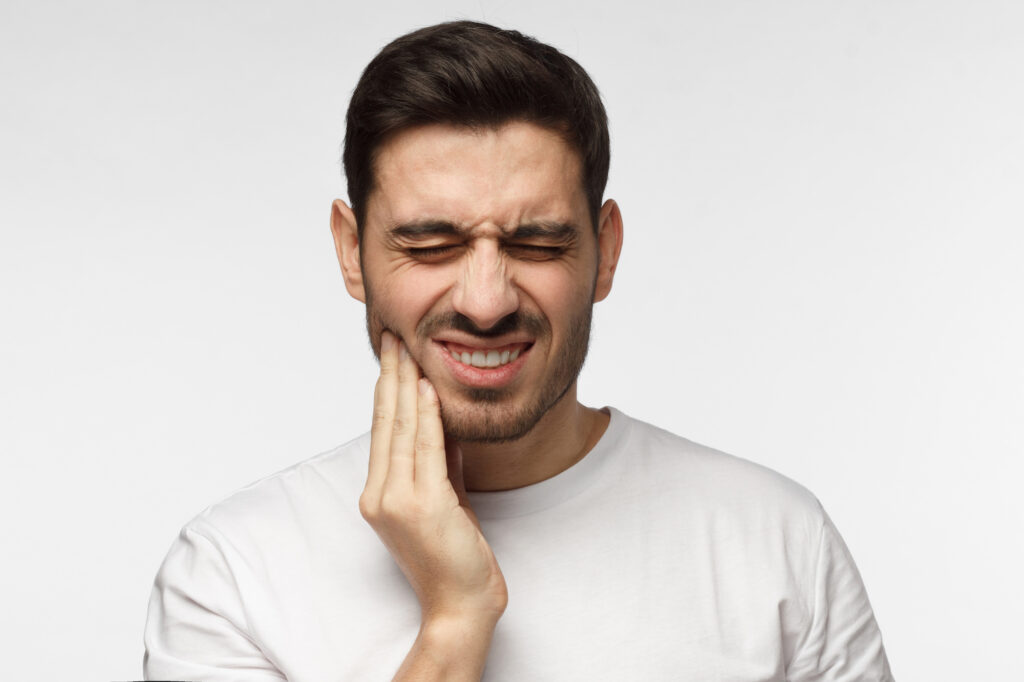 Young man facing tooth pain