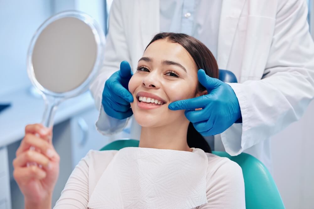 young woman checking her results in the dentists office.