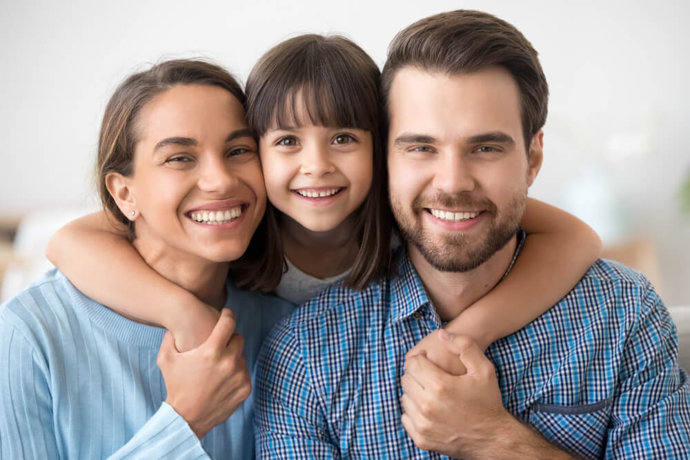 Happy beautiful family of three dad mom and little cute daughter