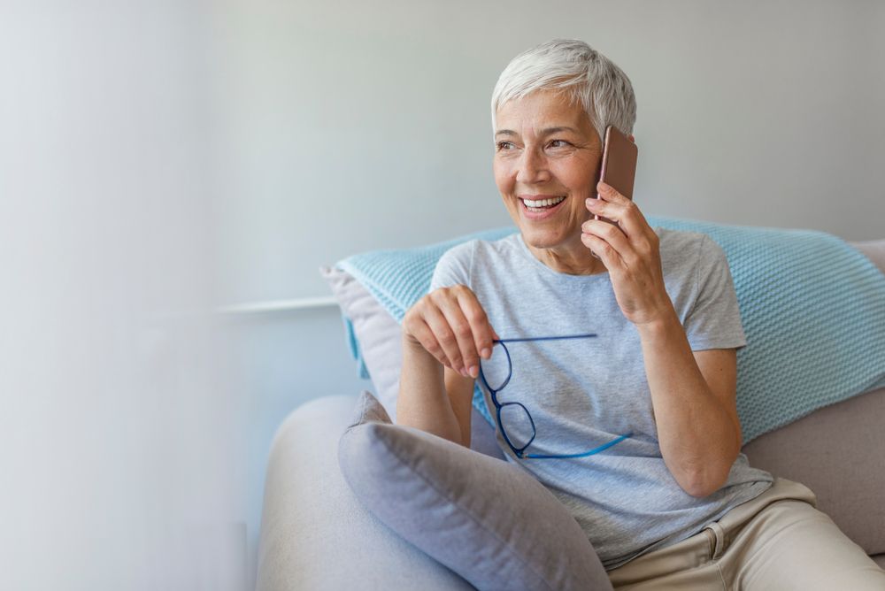 Attractive Senior Woman In Eyeglasses Talking On Smartphone. Portrait Of