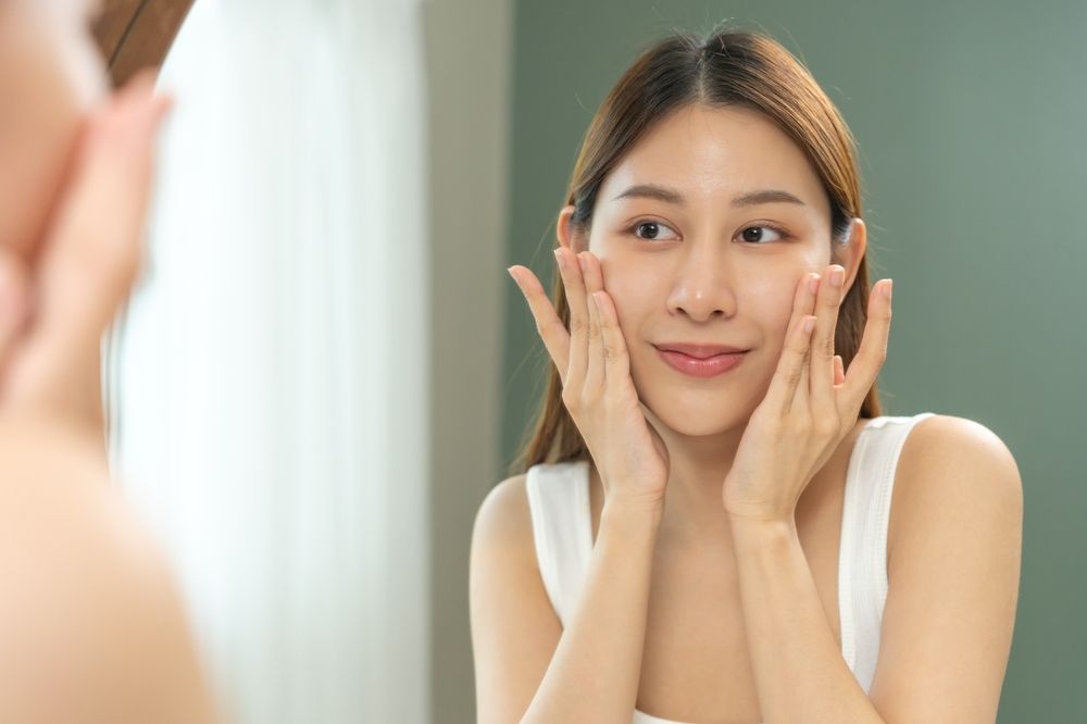 A woman admiring her skin in the mirror after Wrinkle Reduction