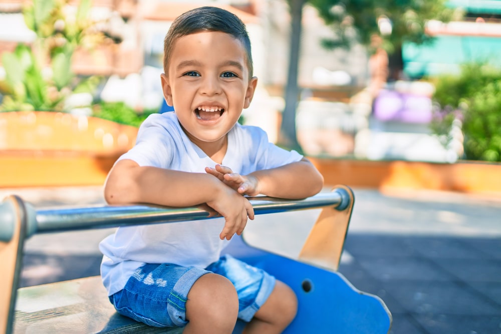 Adorable boy smiling happy playing at the park.