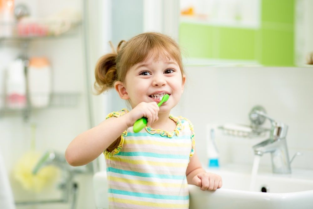 kid girl brushing teeth in bath room