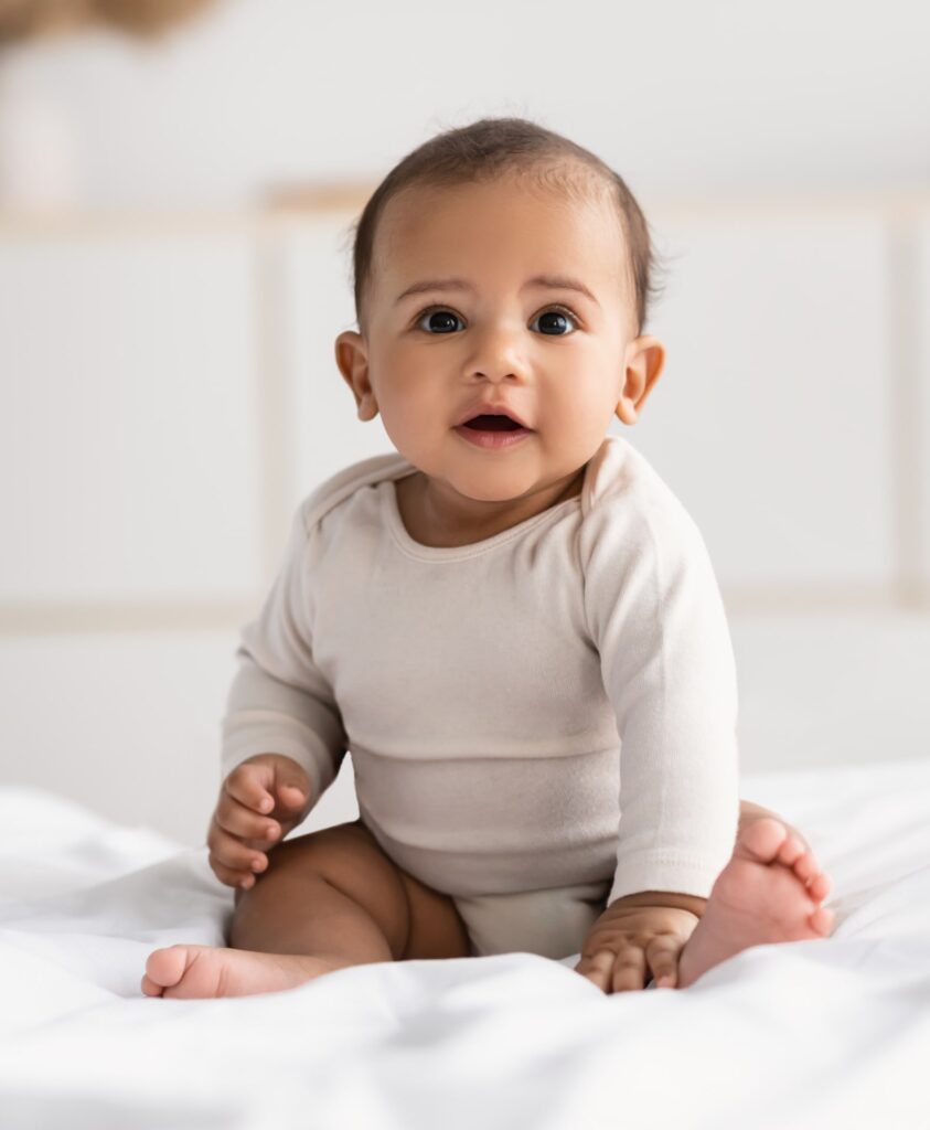 Cute little infant sitting on bed