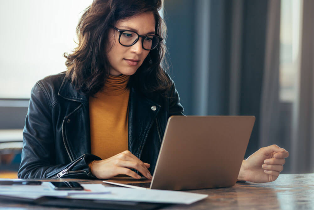 woman busy working on laptop computer at office.