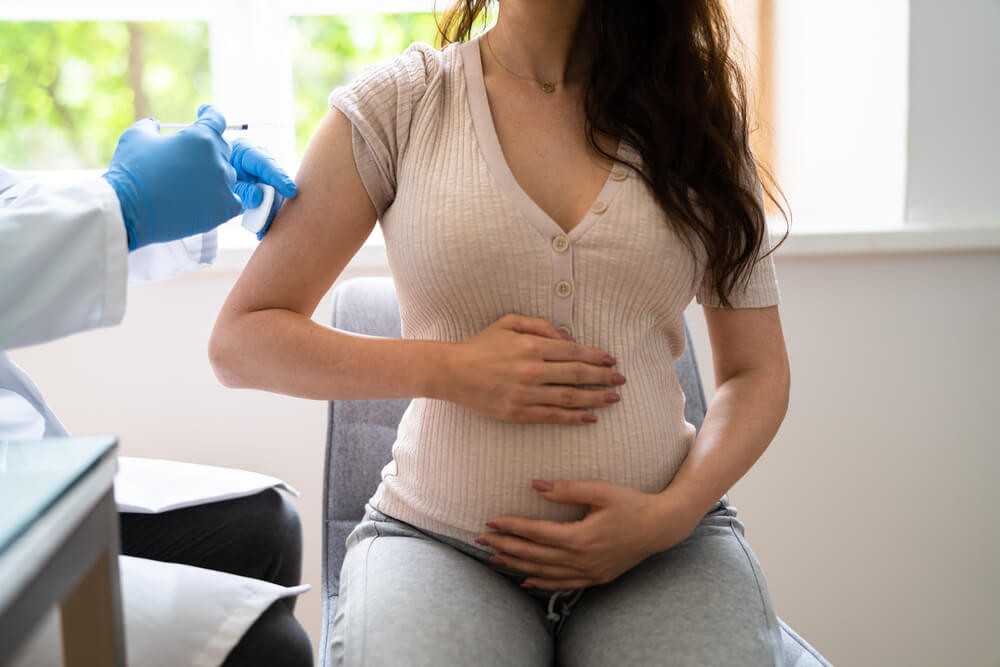 Doctor Making Covid-19 Vaccine Injection To Pregnant Woman Patient