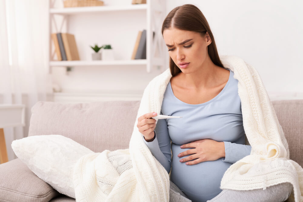 Pregnant Girl Holding Thermometer Measuring Temperature