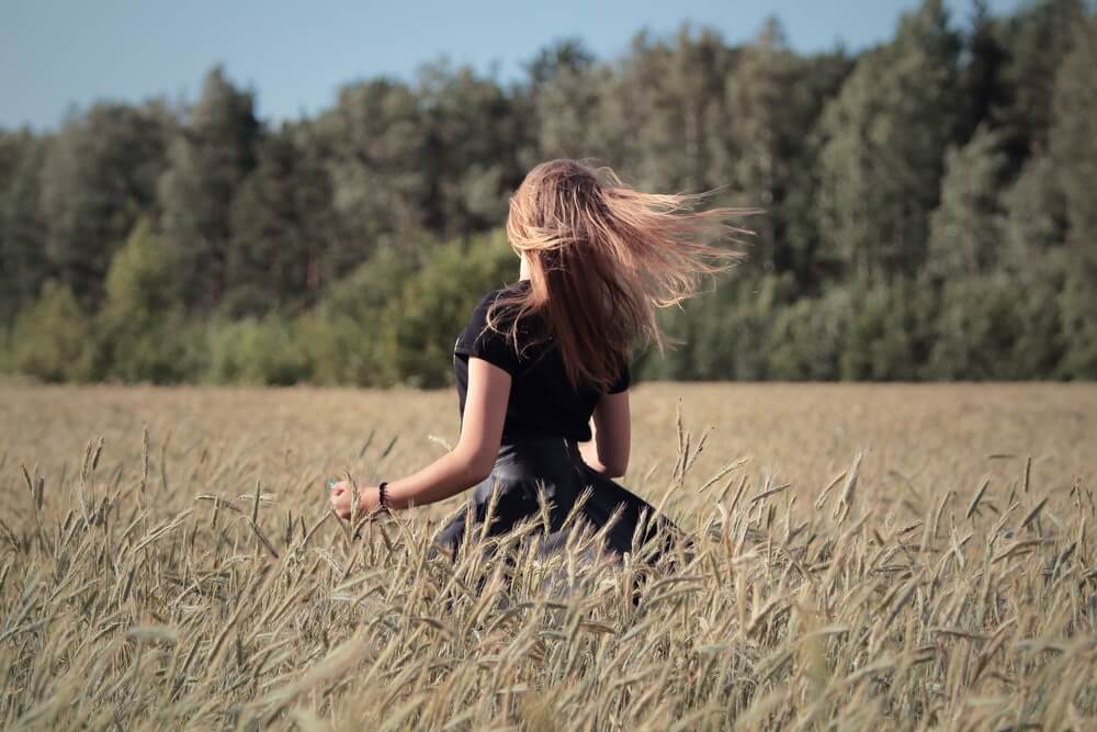 Girl waving her hair in a wheat field