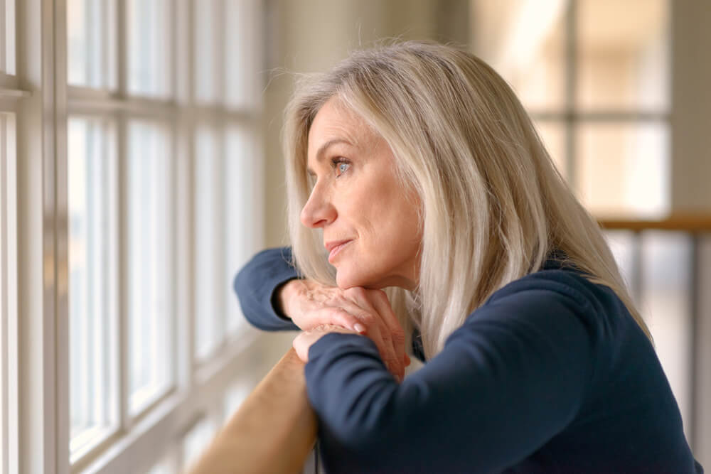 Attractive blond woman standing daydreaming