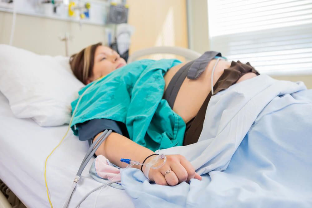 Birthing woman in hospital with IV in arm