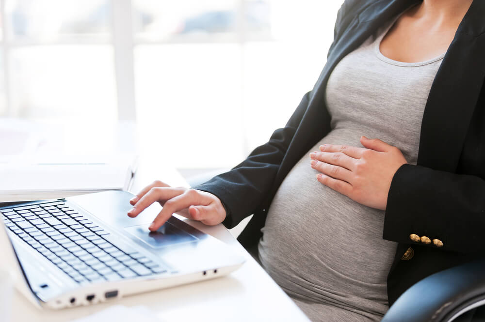 Pregnant woman working on laptop