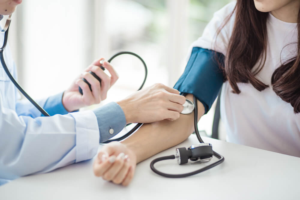 Doctor using sphygmomanometer with stethoscope