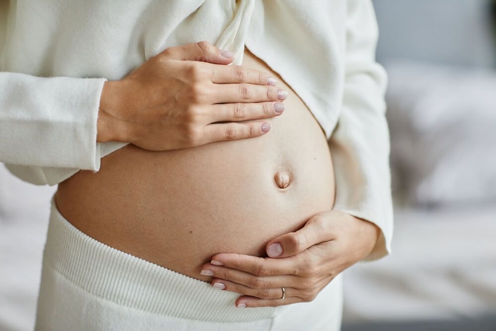 young pregnant woman touching her belly