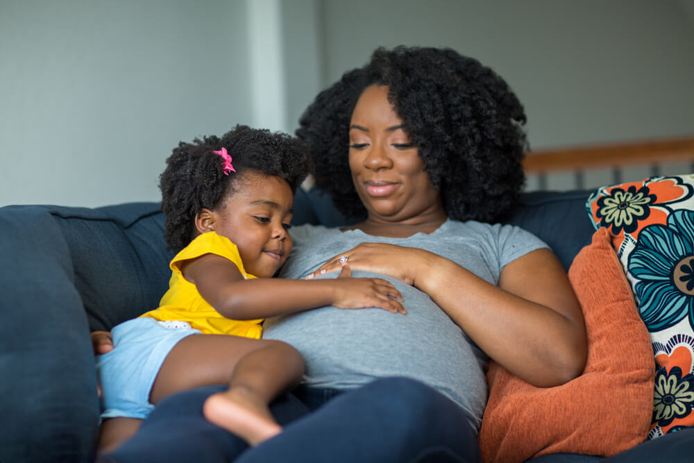 American little girl holding her mother's stomach