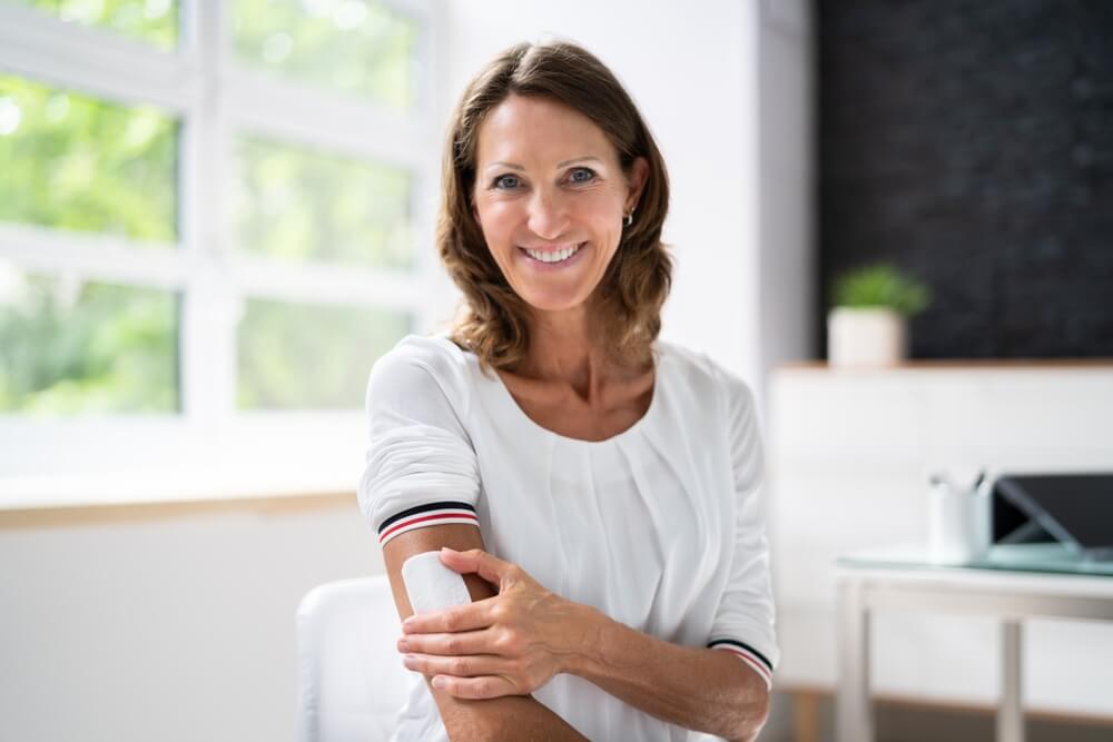 Woman Applying Patch On Her Arm