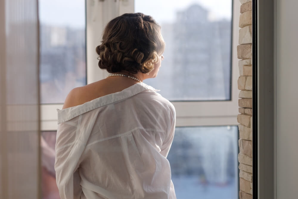 Beautiful girl in a shirt on her naked body looks thoughtfully out