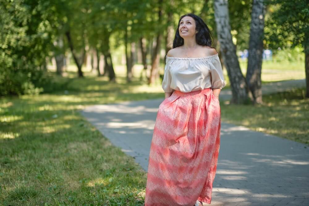 Middle-aged attractive woman with dark hair, enjoying nature in the forest