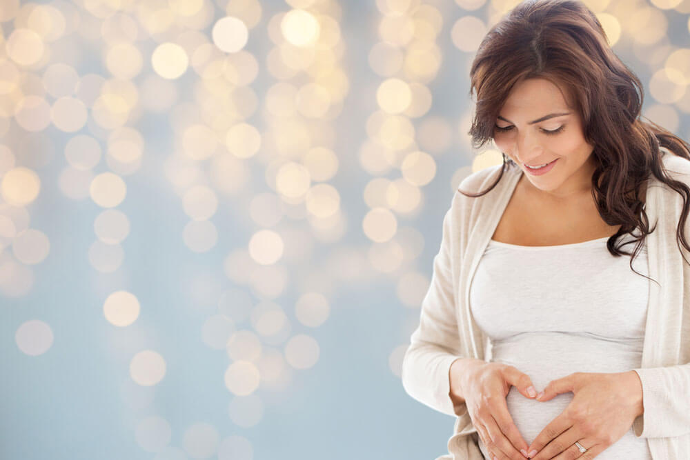 pregnant woman making heart gesture