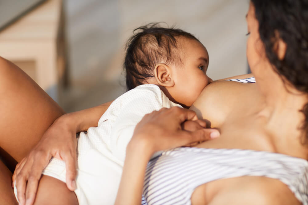 young mother attaching baby at breast