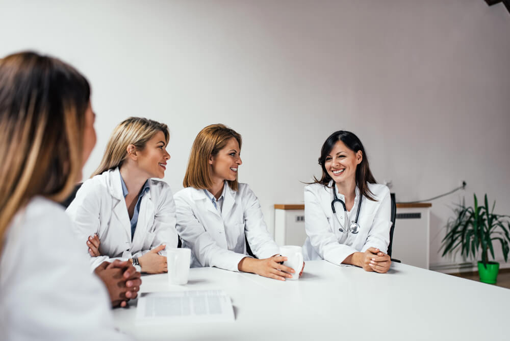 Female hospital staff having a break and talking in the office.