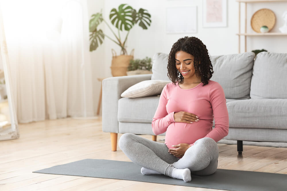 Beautiful happy pregnant woman hugging her tummy,