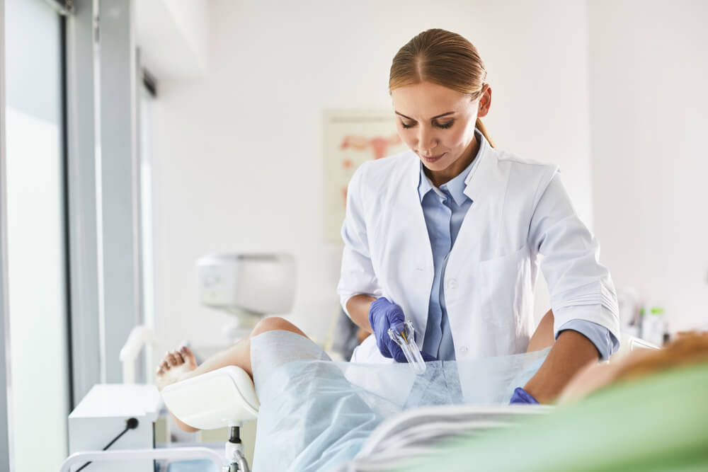 Waist up portrait of gynecologist in white lab coat