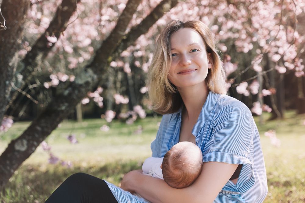 Young woman breast feeding her newborn baby.