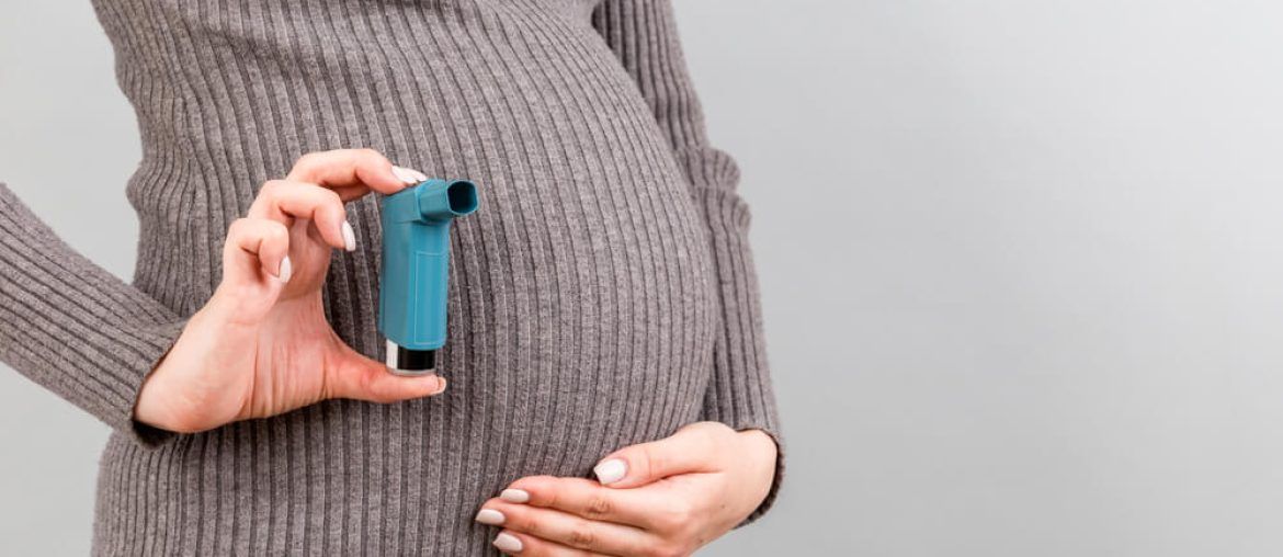 pregnant woman holding asthma inhaler