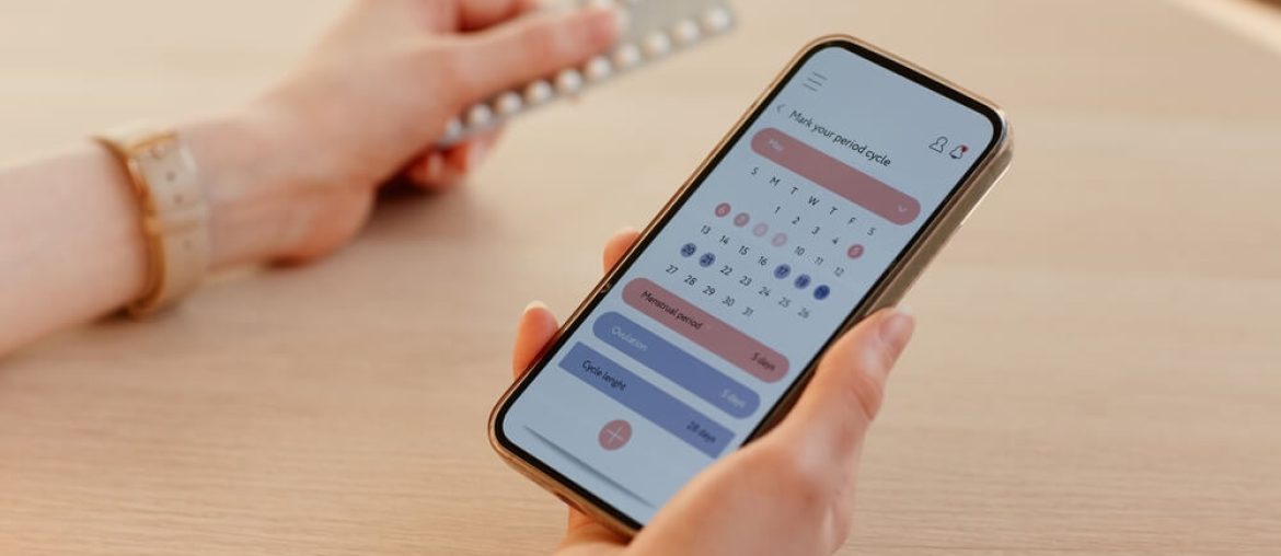 young woman calculating menstrual cycle using mobile app