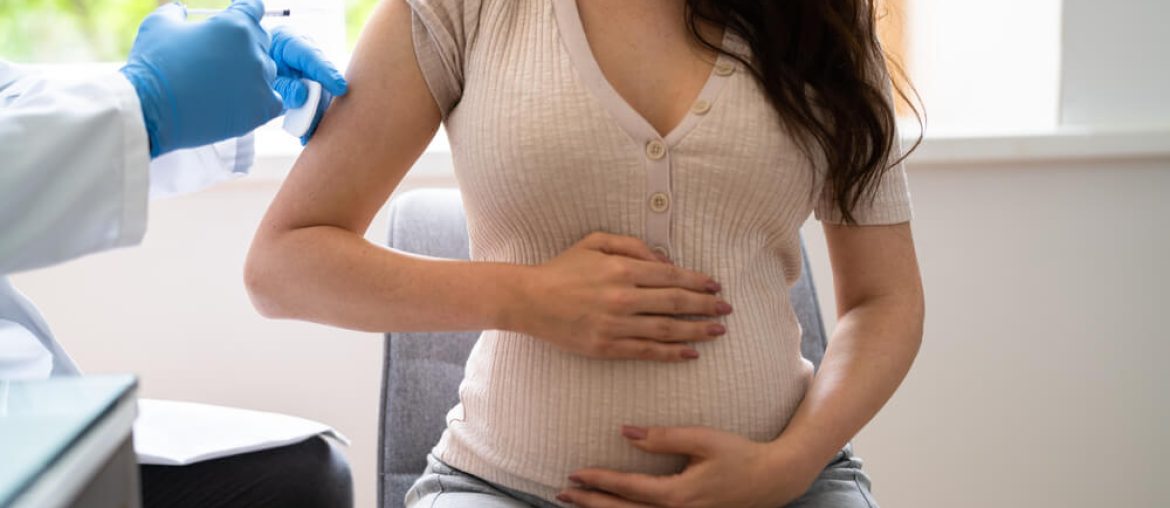 Doctor Making Covid-19 Vaccine Injection To Pregnant Woman Patient