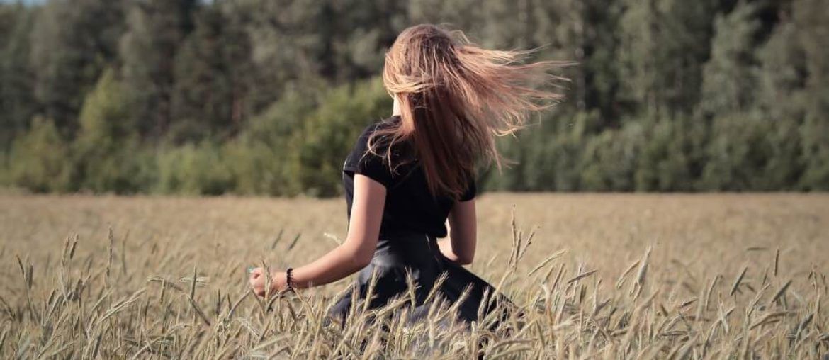 Girl waving her hair in a wheat field