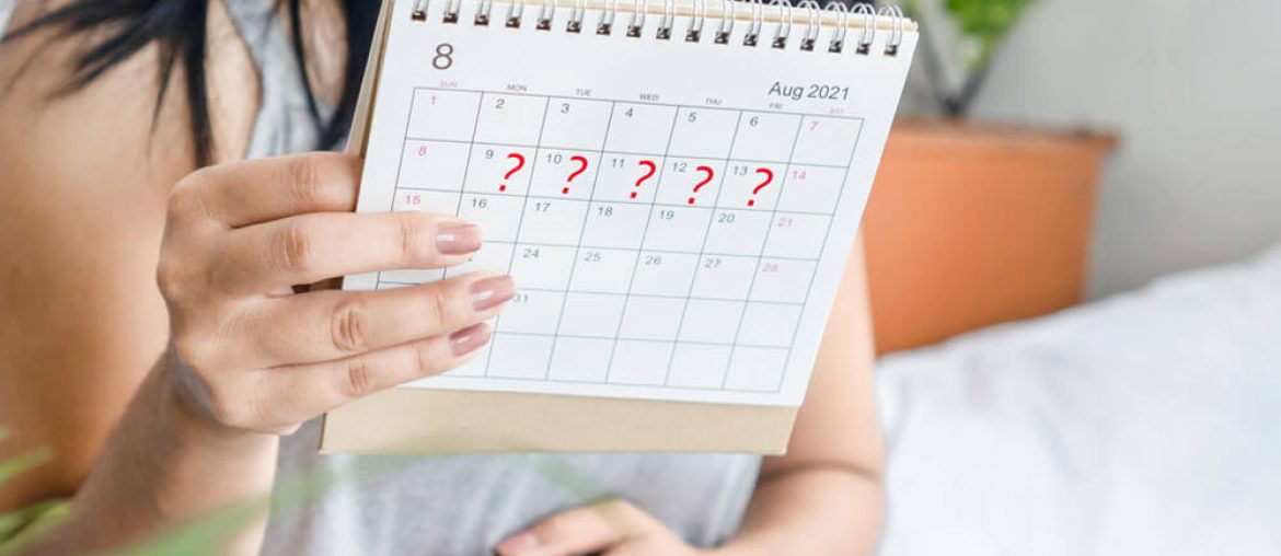 woman hand holding calendar with question mark waiting for late blood period