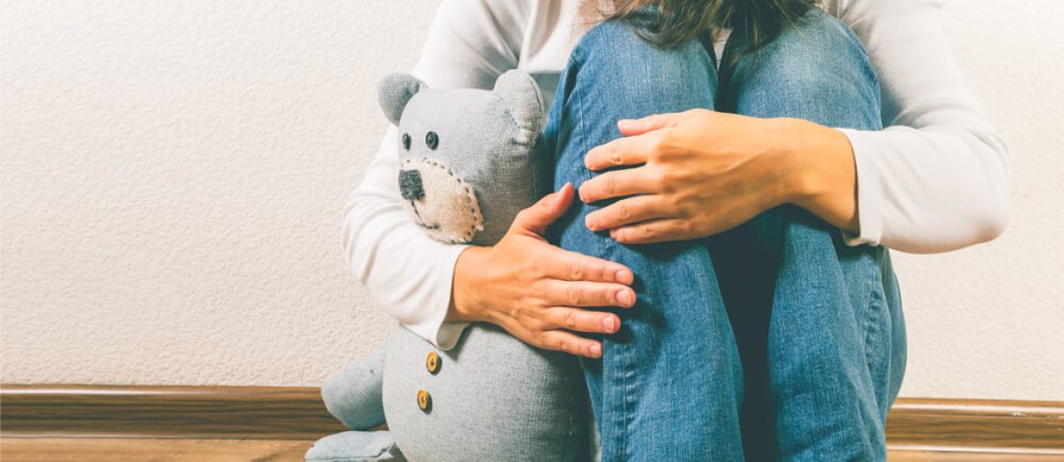 depressed woman holding teddy bear toy