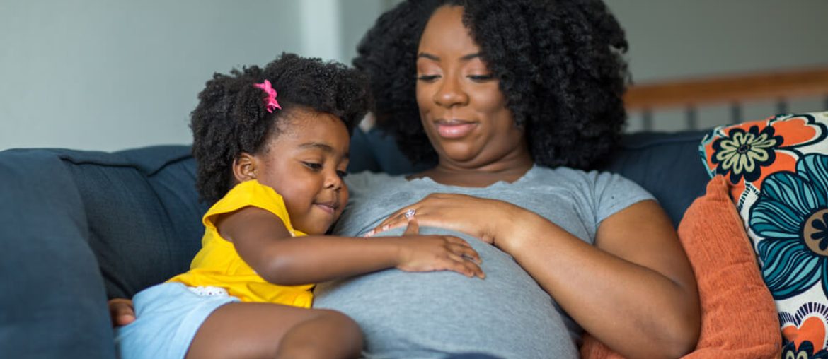 American little girl holding her mother's stomach