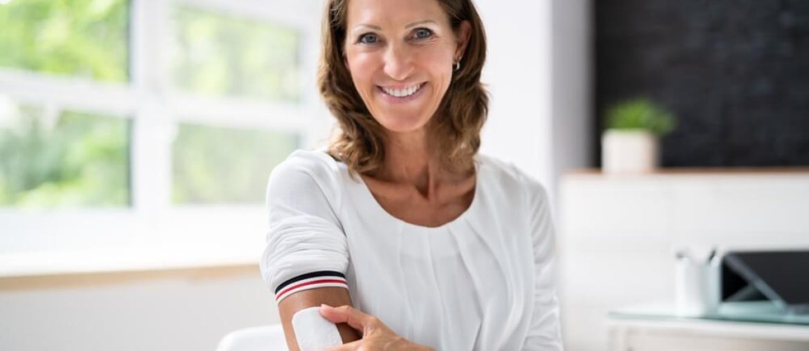 Woman Applying Patch On Her Arm