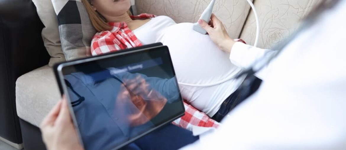 Doctor doing ultrasound of fetus to pregnant woman