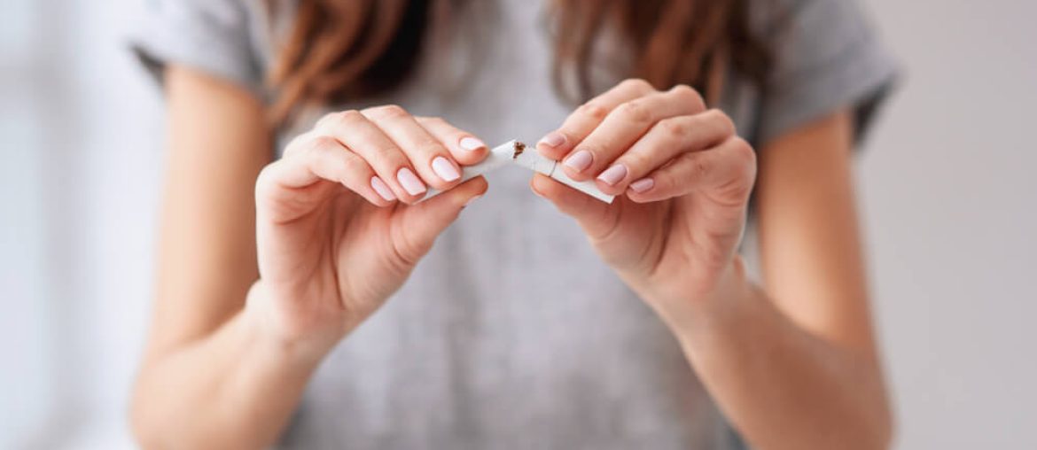 beautiful smiling girl holding broken cigarette in hands.