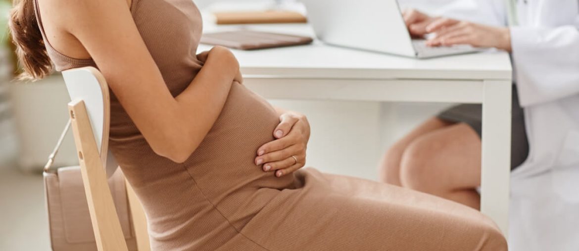 Young pregnant woman visiting her gynecologist in clinic