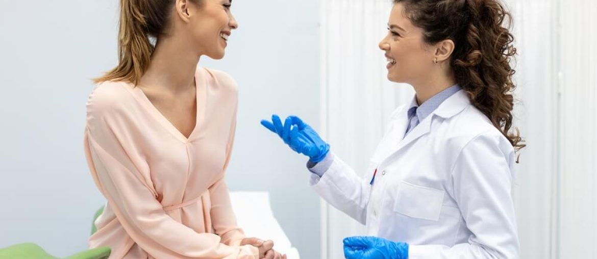 Gynecologist talking with young female patient during medical consultation in modern clinic